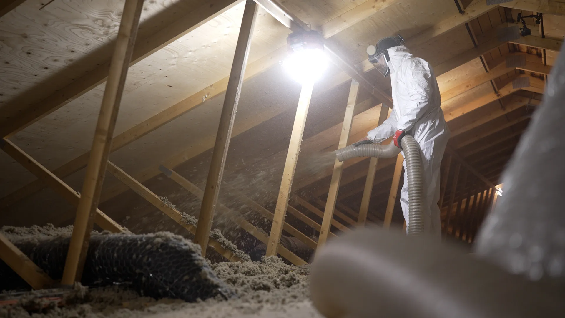 Loftsisolering - professionel isolatør indblæser isolering på et loft